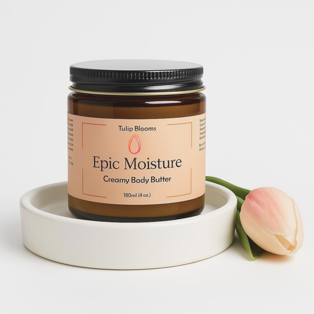 Tulip Blooms Epic Moisture Creamy Body Butter in amber glass jar with blush label and black lid beside a tulip flower